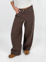 Modelfoto af pige i brun/lyserød MADDY bukser og hvid basic t-shirt. Alt er fra BySofieSønderby.