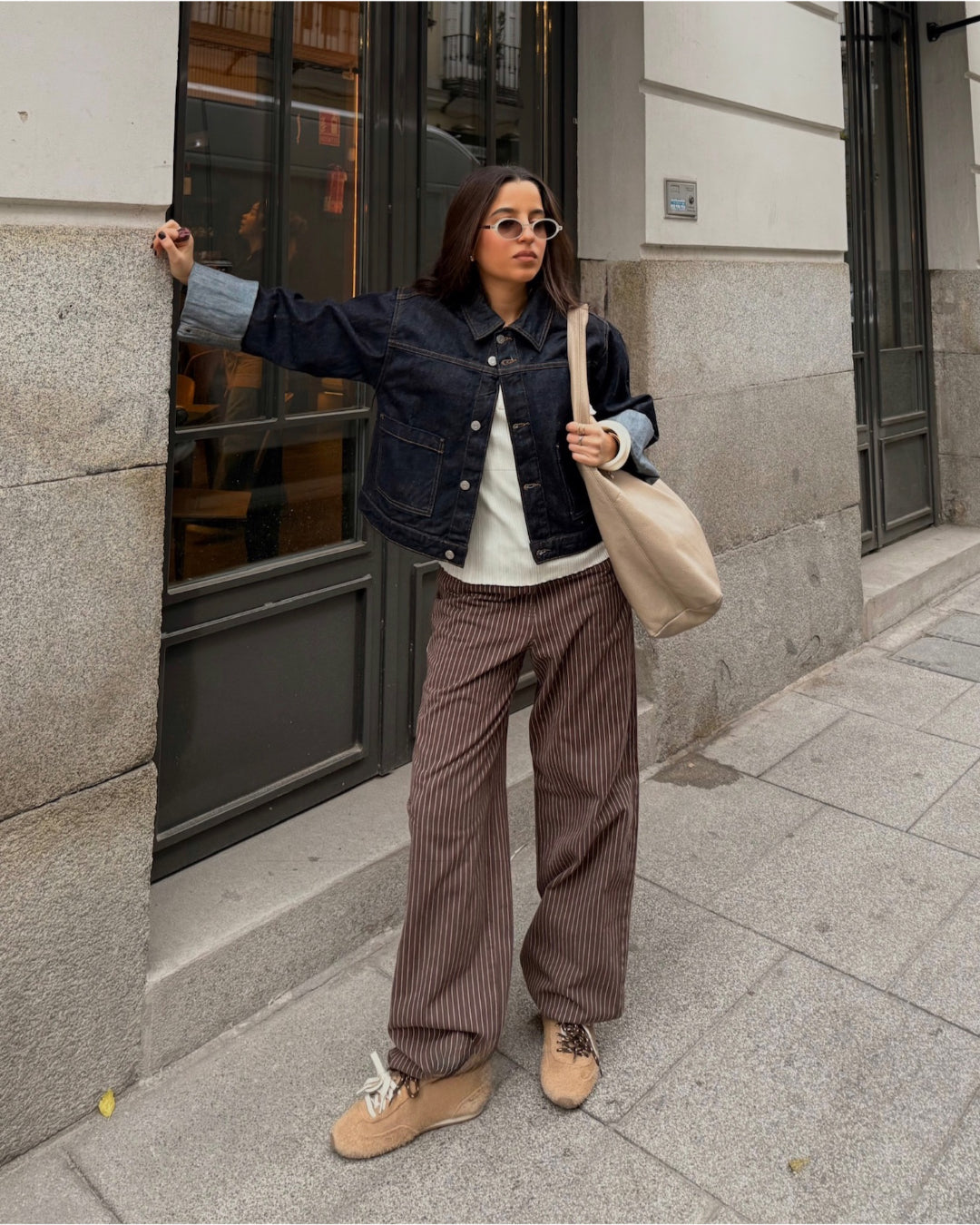 Modelfoto af pige i MADDY bukser i farven brun med lyserøde striber, samt mørkeblå denimjakke.  Fra BySofieSønderby