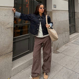 Modelfoto af pige i MADDY bukser i farven brun med lyserøde striber, samt mørkeblå denimjakke.  Fra BySofieSønderby