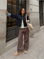 Modelfoto af pige i MADDY bukser i farven brun med lyserøde striber, samt mørkeblå denimjakke.  Fra BySofieSønderby