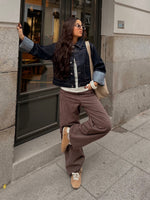 Modelfoto af pige i MADDY bukser i farven brun med lyserøde striber, samt mørkeblå denimjakke.  Fra BySofieSønderby