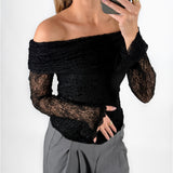 Modelfoto af pige i sort MAISY off-shoulder blondebluse og grå LISA bukser. Alt er fra BySofieSønderby.