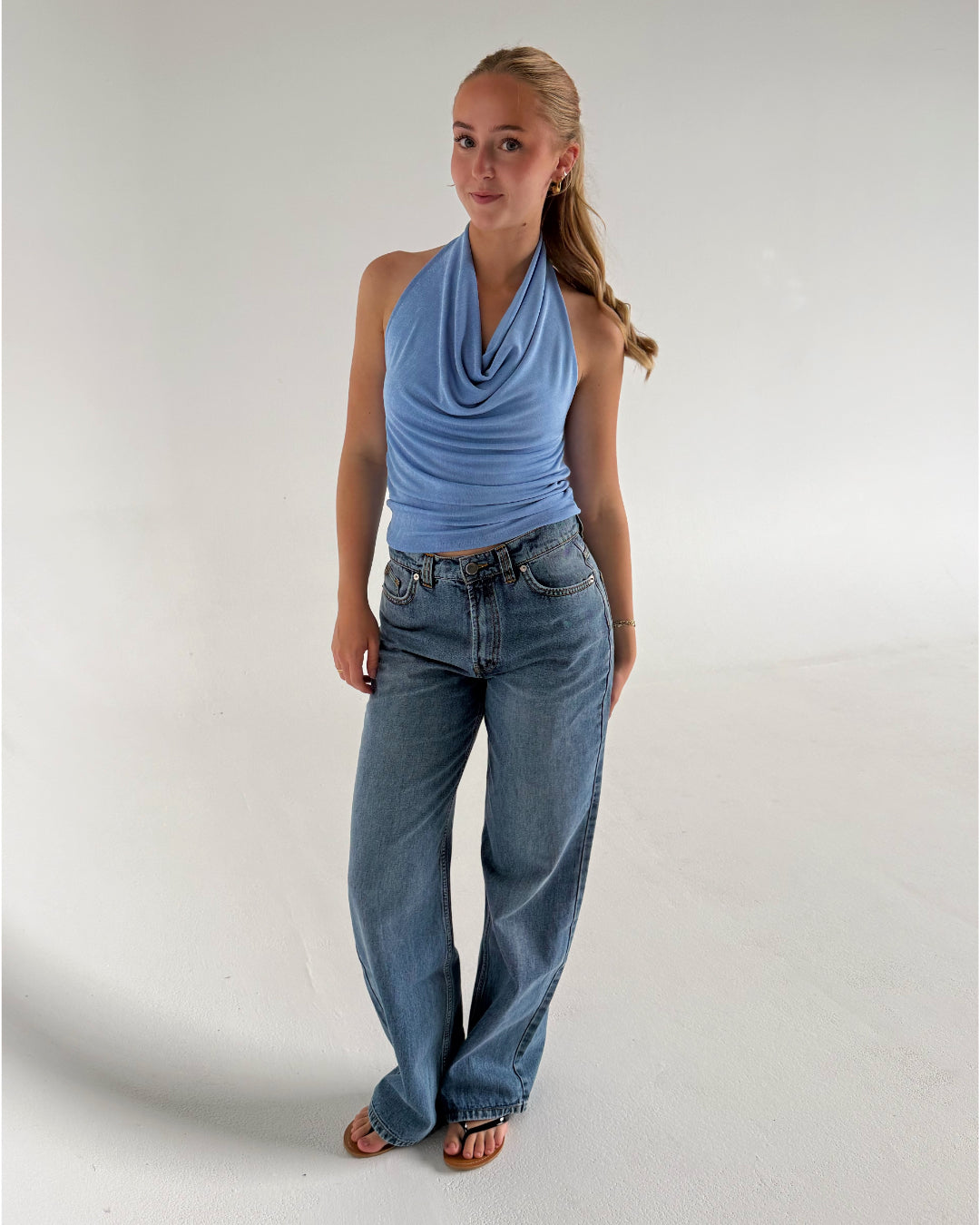 Modelfoto af pige der bærer Mavis top i blå, samt blå Nanna Jeans. Alt fra BySofieSønderby