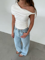 Modelfoto af pige med MILENA off shoulder top, hvid og NANNA jeans, lyseblå - begge fra BySofieSønderby