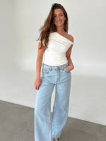 Modelfoto af pige med MILENA off shoulder top, hvid og NANNA jeans, lyseblå - begge fra BySofieSønderby