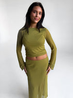 Modelfoto af pige i grøn Minna bluse og grøn Minna nederdel. Alt er fra BySofieSønderby
