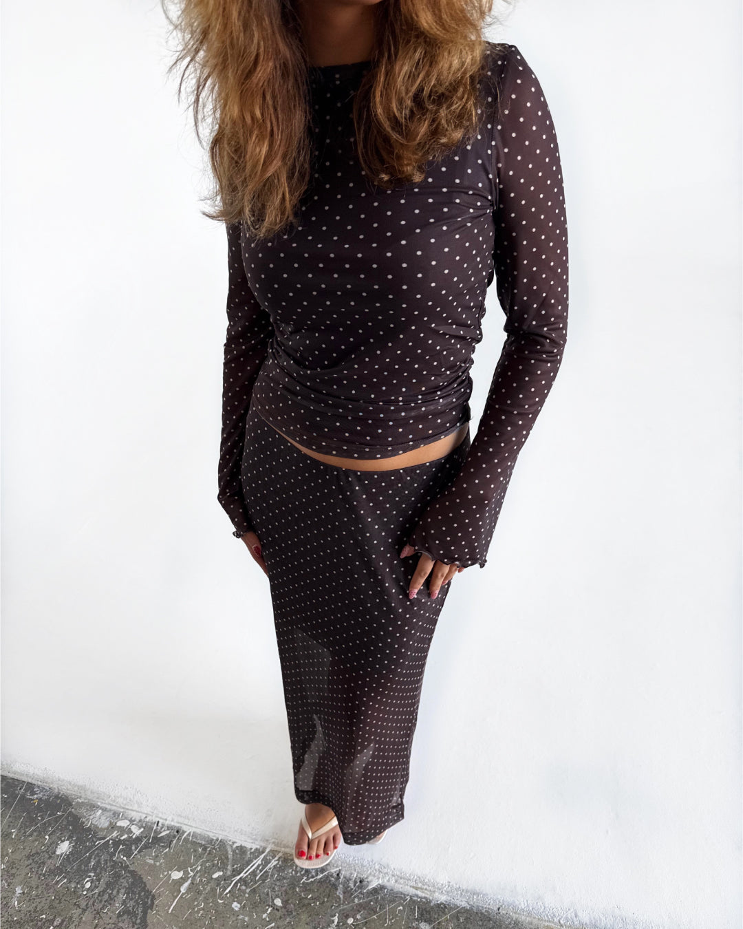 Modelfoto af pige i Minna nederdel og Minna bluse. Begge dele i farven brun med hvide prikker. Alt er fra BySofieSønderby 