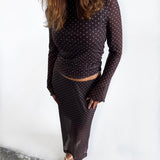 Modelfoto af pige i Minna nederdel og Minna bluse. Begge dele i farven brun med hvide prikker. Alt er fra BySofieSønderby 