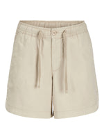 Beige shorts med elastisk talje og snørebånd foran, liggende isoleret mod en hvid baggrund.