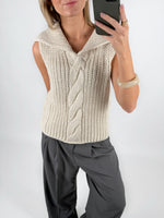 Modelfoto af pige i beige OCEAN strikvest med kabelstrik-detalje  og grå LISA bukser. Alt er fra BySofieSønderby.