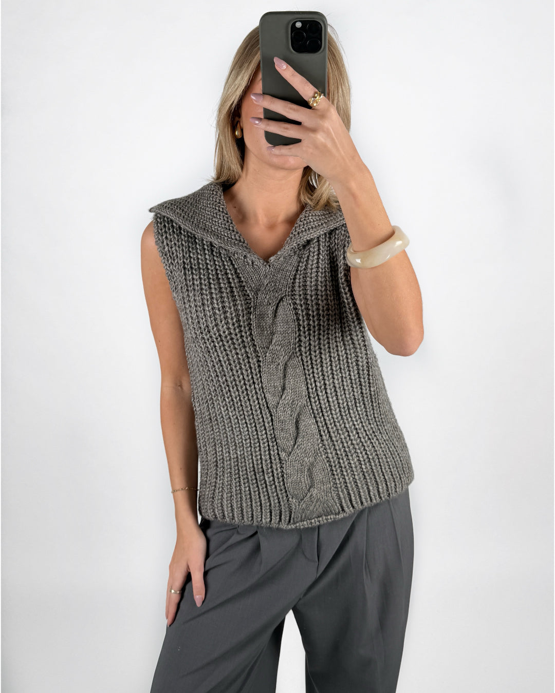 Modelfoto af pige i grå OCEAN strikvest med kabelstrik-detalje  og grå LISA bukser. Alt er fra BySofieSønderby.