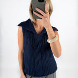 Modelfoto af pige i navy OCEAN strikvest med kabelstrik-detalje  og grå LISA bukser. Alt er fra BySofieSønderby.