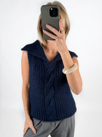 Modelfoto af pige i navy OCEAN strikvest med kabelstrik-detalje  og grå LISA bukser. Alt er fra BySofieSønderby.