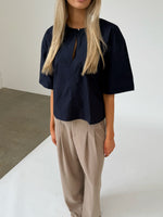 Modelfoto af pige iklædt OLEANE bluse, navy og MILAN bukser, beige - begge fra BySofieSønderby