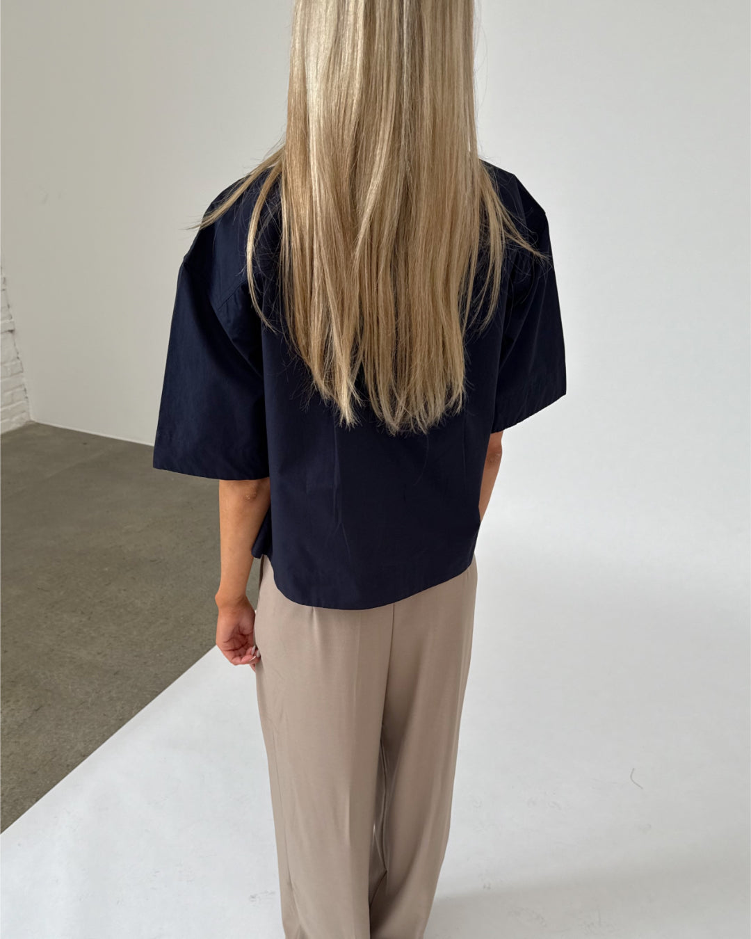Modelfoto af pige iklædt OLEANE bluse, navy og MILAN bukser, beige - begge fra BySofieSønderby