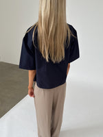 Modelfoto af pige iklædt OLEANE bluse, navy og MILAN bukser, beige - begge fra BySofieSønderby