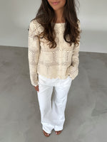 Modelfoto af pige som bærer en cremefarvet ORELLA cardigan med knapper, samt hvide jeans. Alt er fra BySofieSønderby