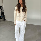 Modelfoto af pige som bærer en cremefarvet ORELLA cardigan med knapper, samt hvide jeans. Alt er fra BySofieSønderby