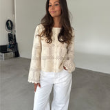 Modelfoto af pige som bærer en cremefarvet ORELLA cardigan med knapper, samt hvide jeans. Alt er fra BySofieSønderby