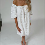 Modelfoto af pige som bærer hvid PALMA off-shoulder kjole med mønster. Alt er fra BySofieSønderby