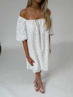Modelfoto af pige som bærer hvid PALMA off-shoulder kjole med mønster. Alt er fra BySofieSønderby