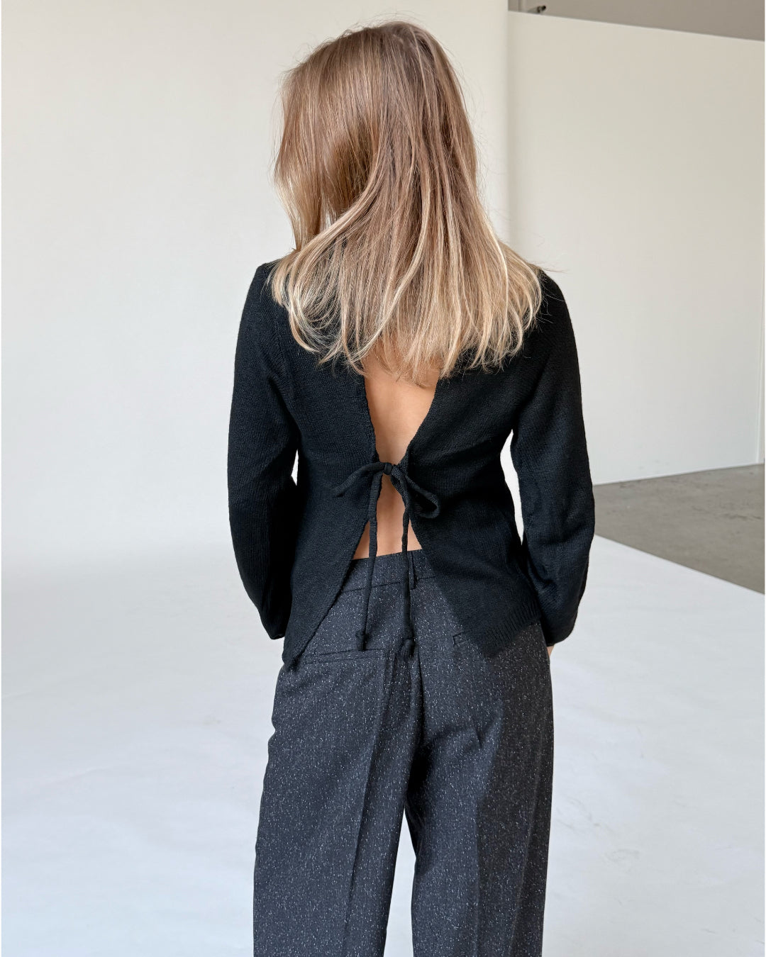 Modelfoto af pige i sort PATRICE strik, samt sortmelerede ELLIS bukser. Alt er fra BySofieSønderby.