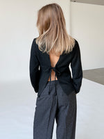 Modelfoto af pige i sort PATRICE strik, samt sortmelerede ELLIS bukser. Alt er fra BySofieSønderby.