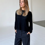 Modelfoto af pige i sort PATRICE strik, samt sortmelerede ELLIS bukser. Alt er fra BySofieSønderby.