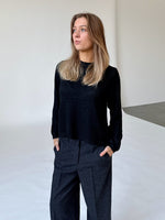 Modelfoto af pige i sort PATRICE strik, samt sortmelerede ELLIS bukser. Alt er fra BySofieSønderby.