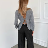 Modelfoto af pige i grå PATRICE strik, samt sortmelerede ELLIS bukser. Alt er fra BySofieSønderby.