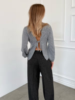 Modelfoto af pige i grå PATRICE strik, samt sortmelerede ELLIS bukser. Alt er fra BySofieSønderby.