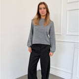 Modelfoto af pige i grå PATRICE strik, samt sortmelerede ELLIS bukser. Alt er fra BySofieSønderby.