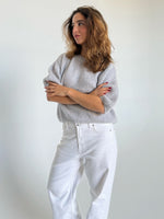 Modelfoto af pige i lysegrå Poppy strik t-shirt og hvide Nanna jeans. Alt er fra BySofieSønderby