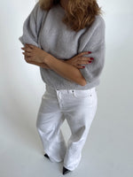Modelfoto af pige i lysegrå Poppy strik t-shirt og hvide Nanna jeans. Alt er fra BySofieSønderby