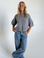 Modelfoto af pige i mørkegrå Poppy strik t-shirt og hvide Nanna jeans. Alt er fra BySofieSønderby