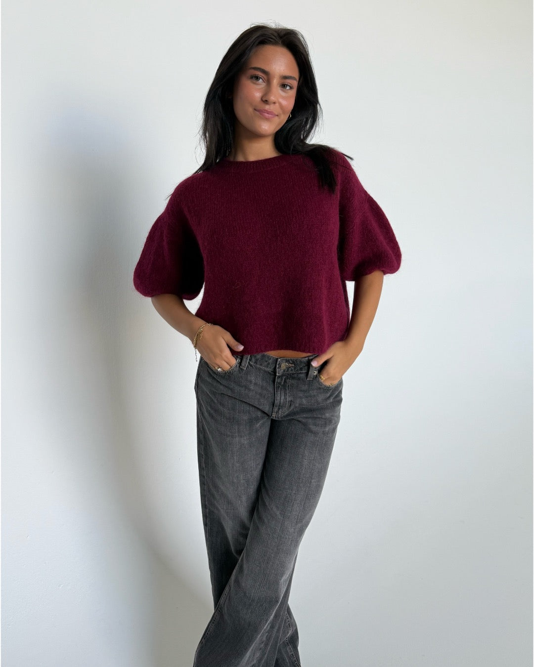 Modelfoto af pige i bordeaux Poppy strik t-shirt og grå Nanna jeans. Alt er fra BySofieSønderby