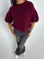 Modelfoto af pige i bordeaux Poppy strik t-shirt og grå Nanna jeans. Alt er fra BySofieSønderby