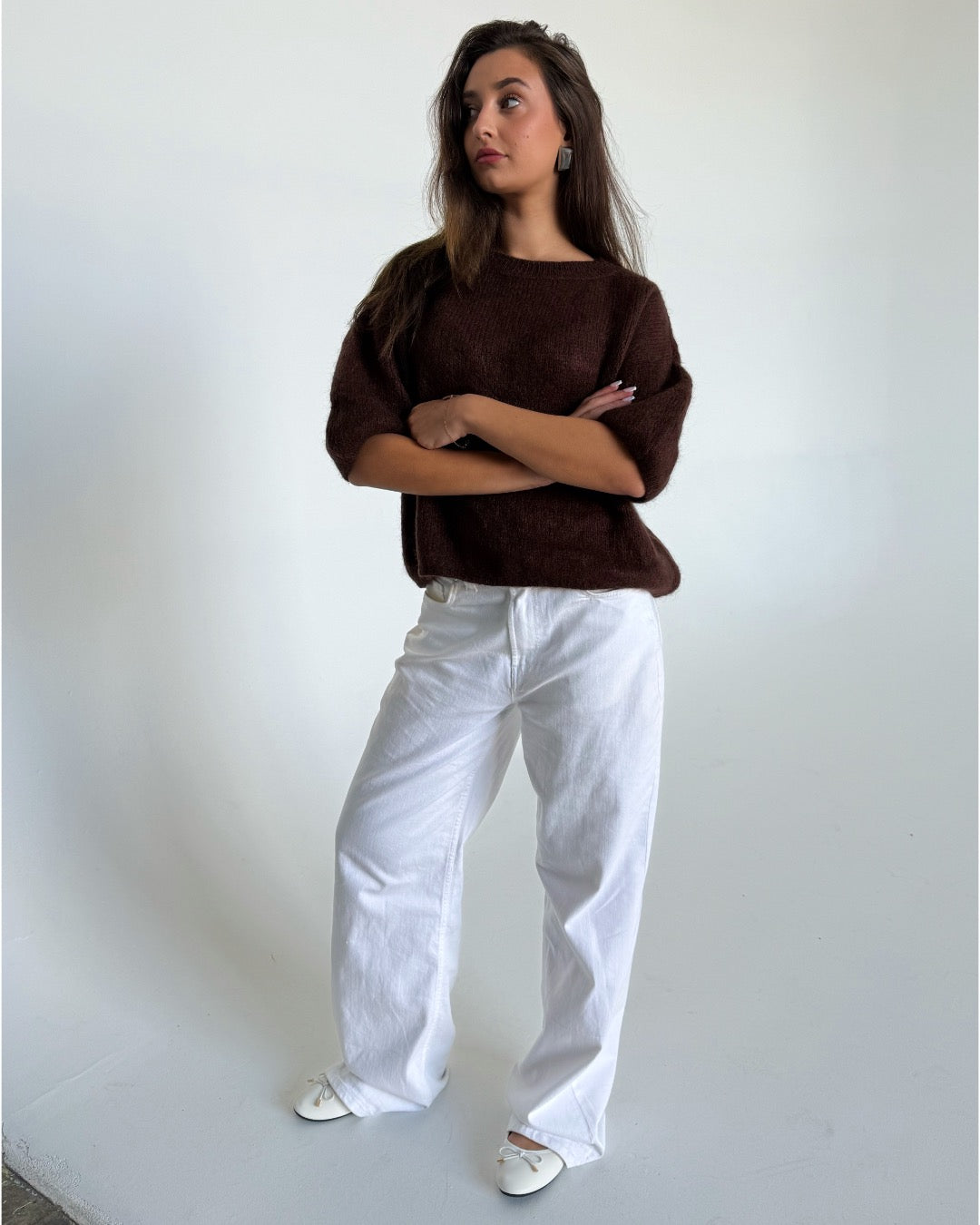 Modelfoto af pige i brun Poppy strik t-shirt og hvide Nanna jeans. Alt er fra BySofieSønderby