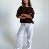 Modelfoto af pige i brun Poppy strik t-shirt og hvide Nanna jeans. Alt er fra BySofieSønderby