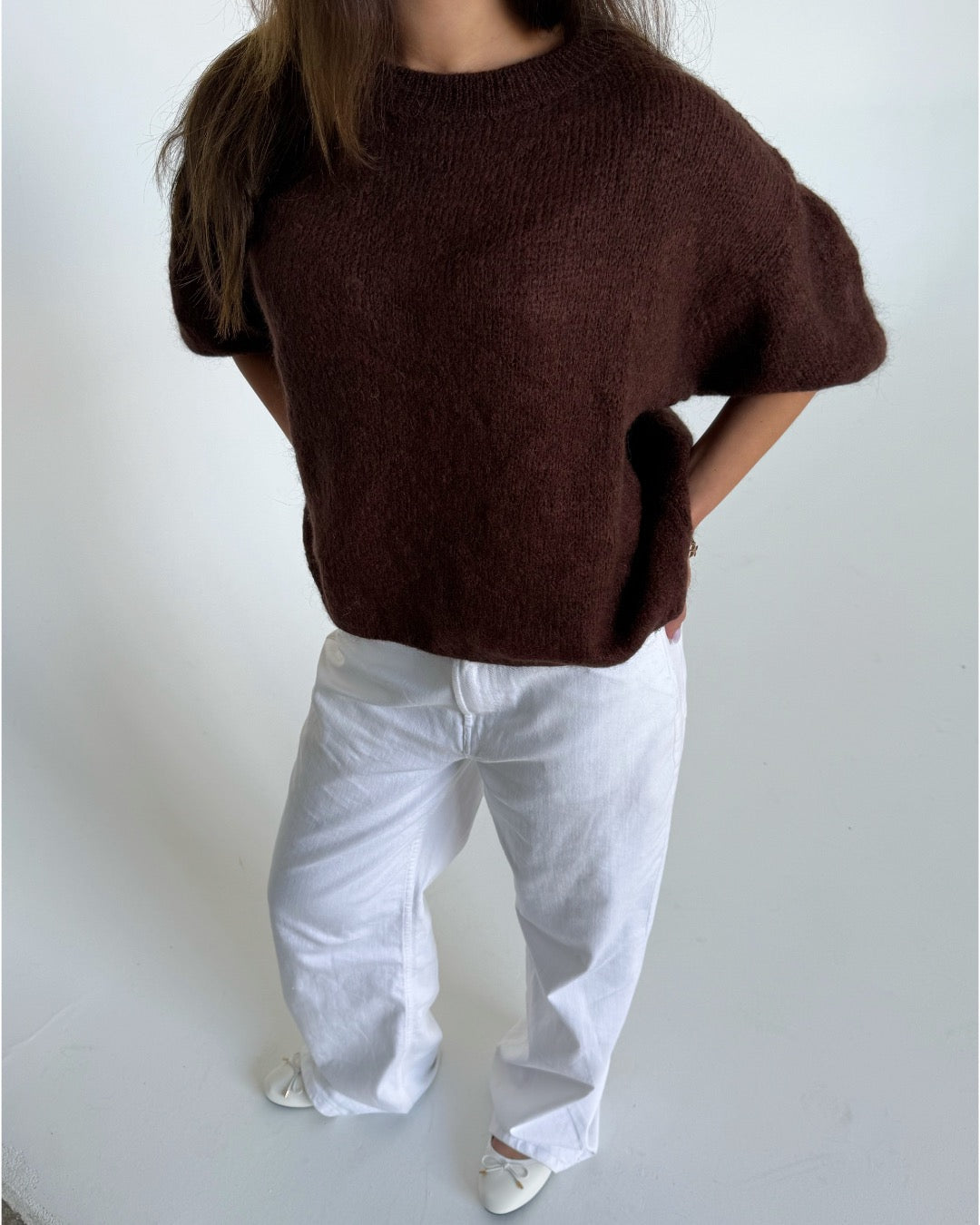 Modelfoto af pige i brun Poppy strik t-shirt og hvide Nanna jeans. Alt er fra BySofieSønderby