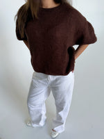 Modelfoto af pige i brun Poppy strik t-shirt og hvide Nanna jeans. Alt er fra BySofieSønderby