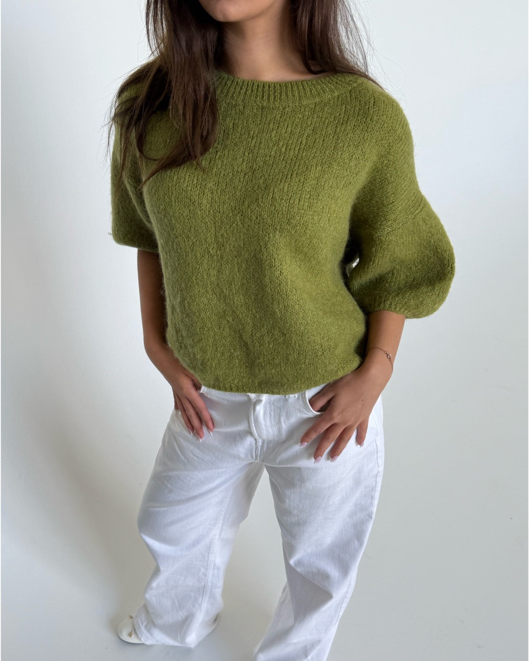 Modelfoto af pige i grøn Poppy strik t-shirt og hvide Nanna jeans. Alt er fra BySofieSønderby
