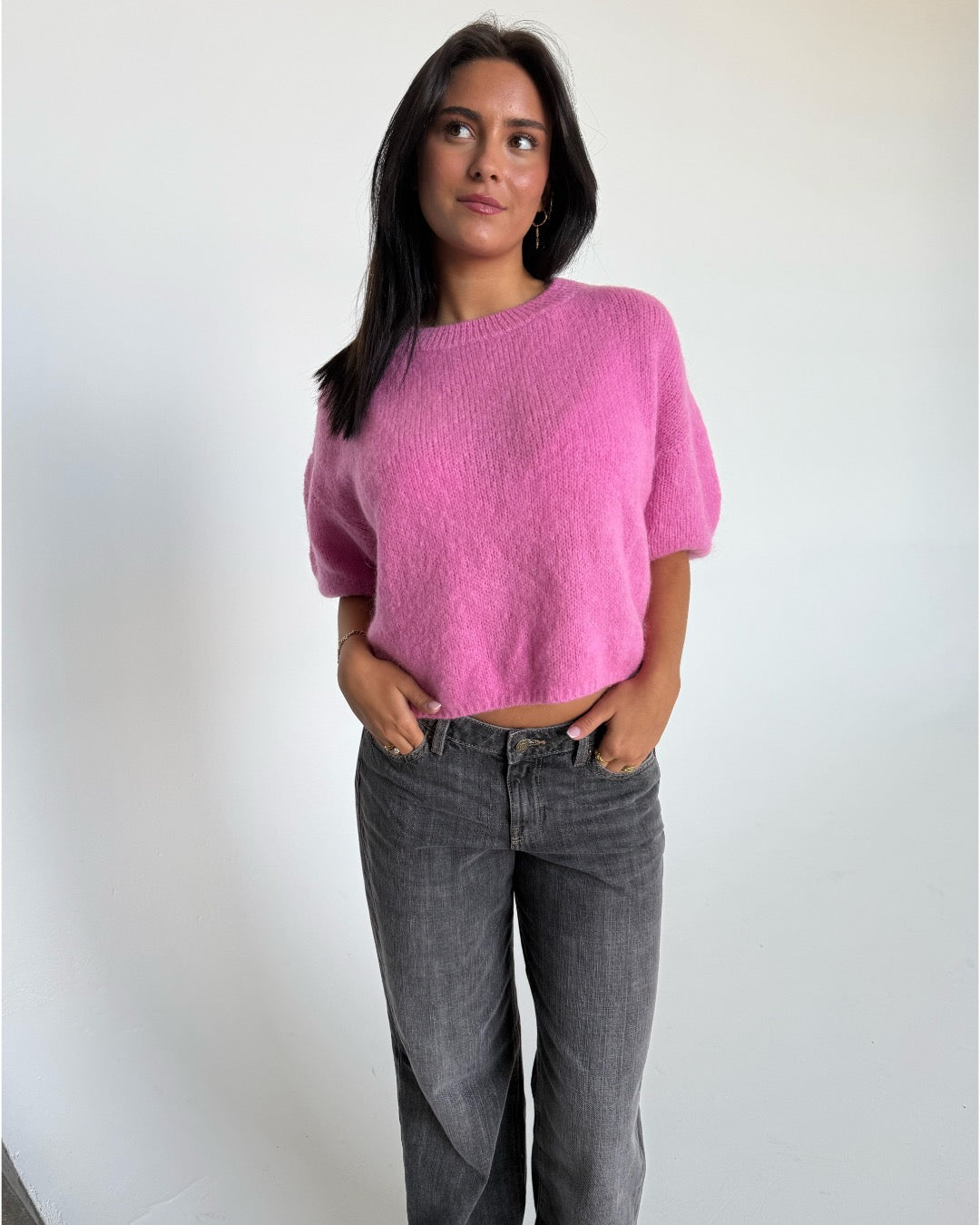 Modelfoto af pige i pink Poppy strik t-shirt og hvide Nanna jeans. Alt er fra BySofieSønderby