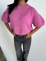 Modelfoto af pige i pink Poppy strik t-shirt og hvide Nanna jeans. Alt er fra BySofieSønderby