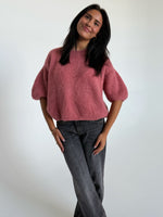 Modelfoto af pige i rosa Poppy strik t-shirt og grå Nanna jeans. Alt er fra BySofieSønderby