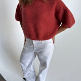 Modelfoto af pige i terracottafarvet Poppy strik t-shirt og hvide Nanna jeans. Alt er fra BySofieSønderby