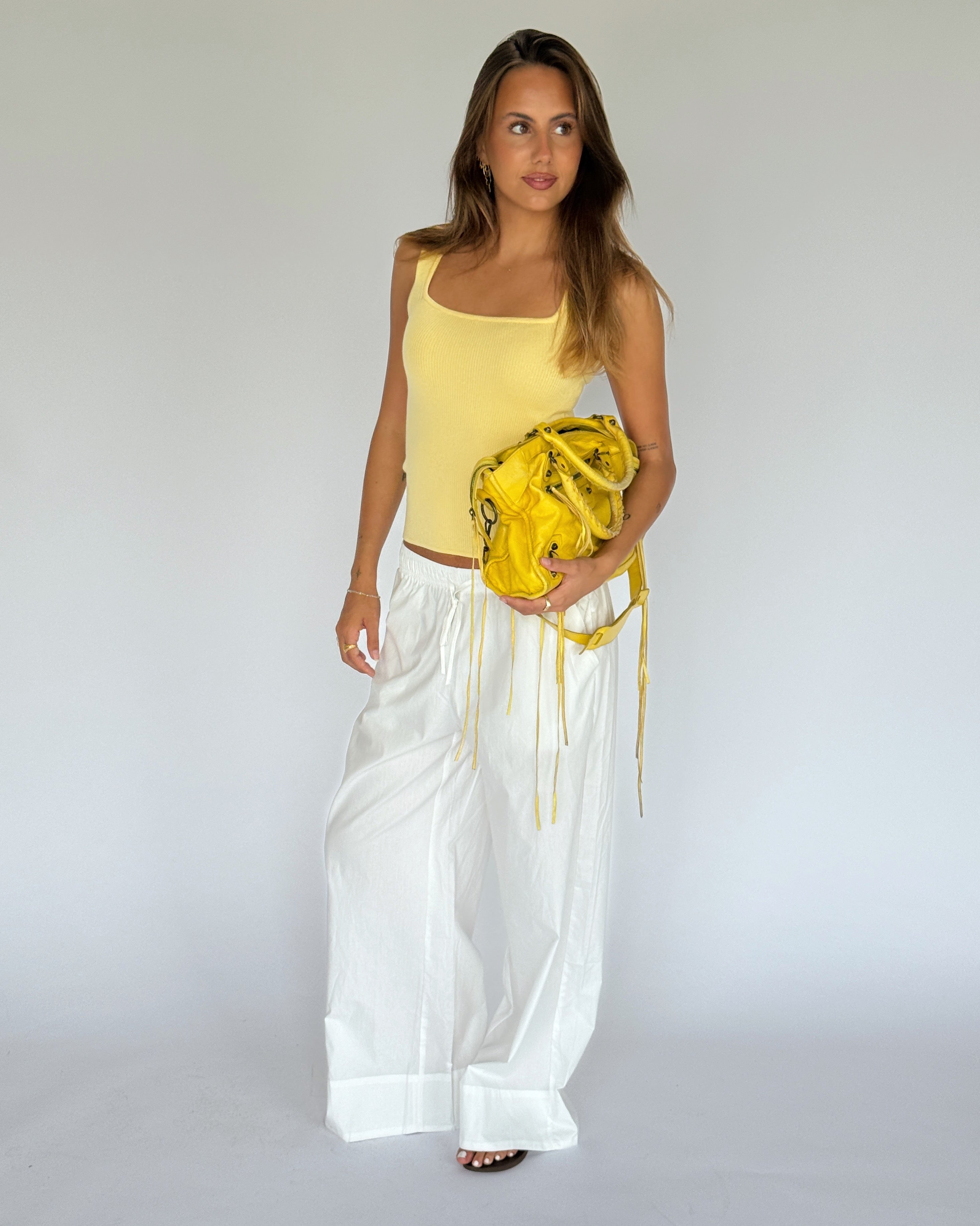 Modelbillede af POSIE strik top, gul og DANIA wide leg bukser, hvid. Begge fra BySofieSønderby