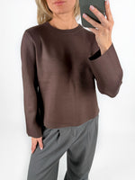 Modelfoto af pige i brun REYNARD strik, samt grå LISA bukser. Alt er fra BySofieSønderby.