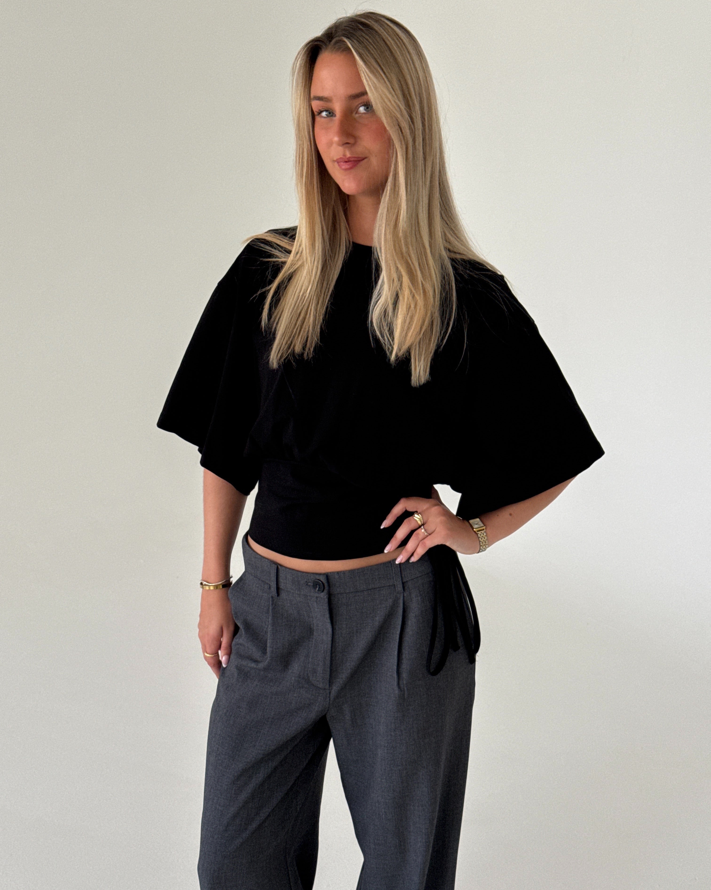 Modelbillede af RITA kortærmet bluse, sort og KARI bukser, grå. Begge fra BySofieSønderby