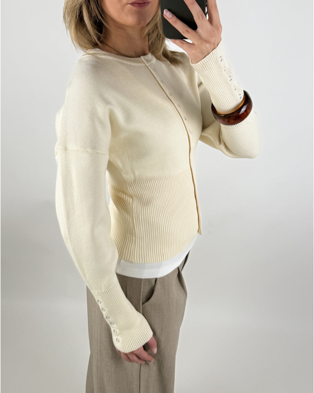 Stemningsbillede af pige der bærer en creme farvet RORY cardigan. Fra BySofieSønderby